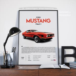 May include: A framed poster of a red 1971 Ford Mustang Mach 1. The poster displays the car's name in large red letters, specifications, and the text "2 Design Variants". A black desk lamp and an open book are in the foreground.