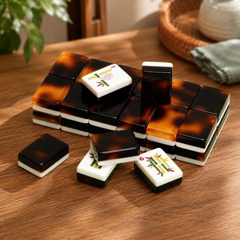 May include: A set of rectangular mahjong tiles featuring a two-tone design with a dark brown tortoiseshell pattern on the top half and a solid white base. Some tiles display green bamboo and red character engravings on their white faces.