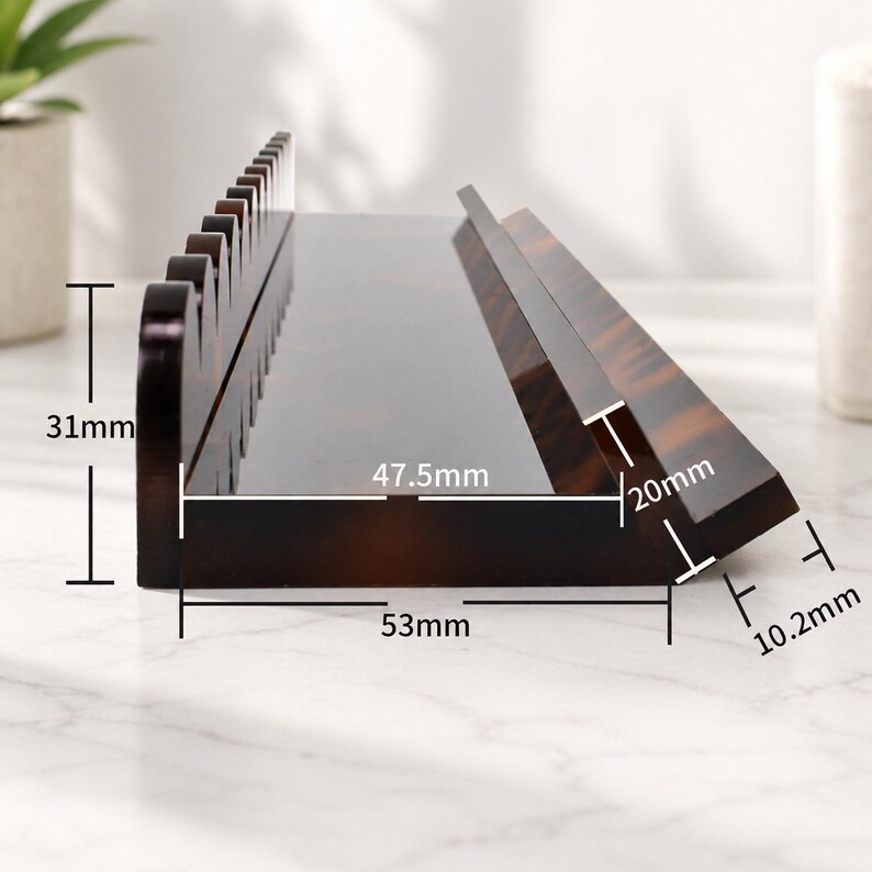 May include: A brown, tortoise-shell patterned desk organizer. The organizer is 53mm long, 31mm tall, and 10.2mm thick. The angled section is 20mm tall and 47.5mm long. The top edge has a series of decorative cutouts.