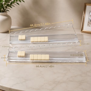 May include: Two clear acrylic shelves, each 17.48 inches long, with scalloped edges. Each shelf holds several small, rectangular, off-white objects. The shelves are 2.56 inches and 1.18 inches wide, respectively.