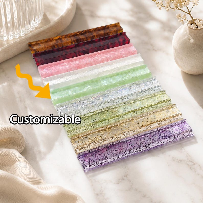 May include: A collection of colorful, rectangular, customizable decorative pieces. The pieces are arranged in a layered stack, showcasing a variety of colors including brown, red, pink, white, green, silver, gold, and purple. The word "Customizable" is displayed.