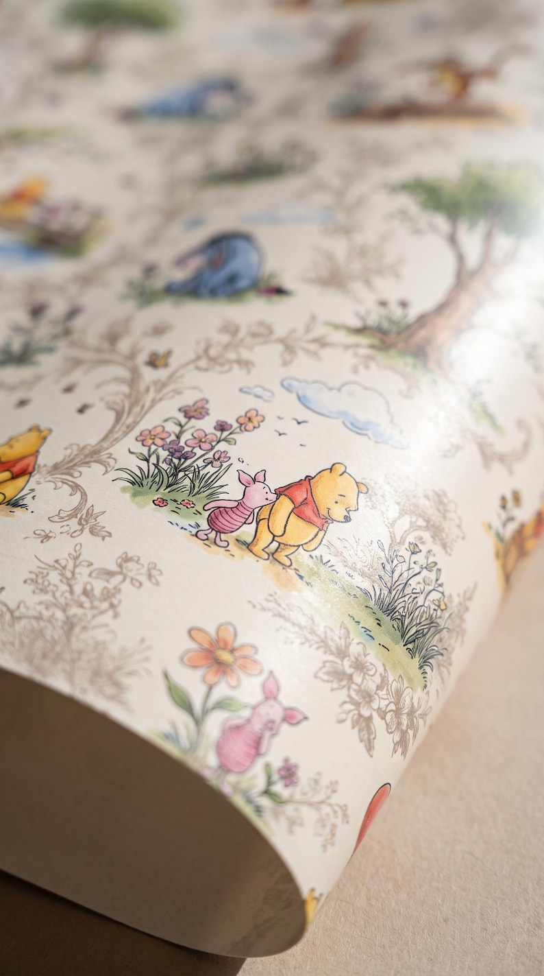 May include: A roll of wallpaper featuring a repeating pattern of Winnie the Pooh, Piglet, and Eeyore in a forest setting. The design includes delicate line drawings of trees and flowers with soft watercolor accents in yellow, pink, and blue.