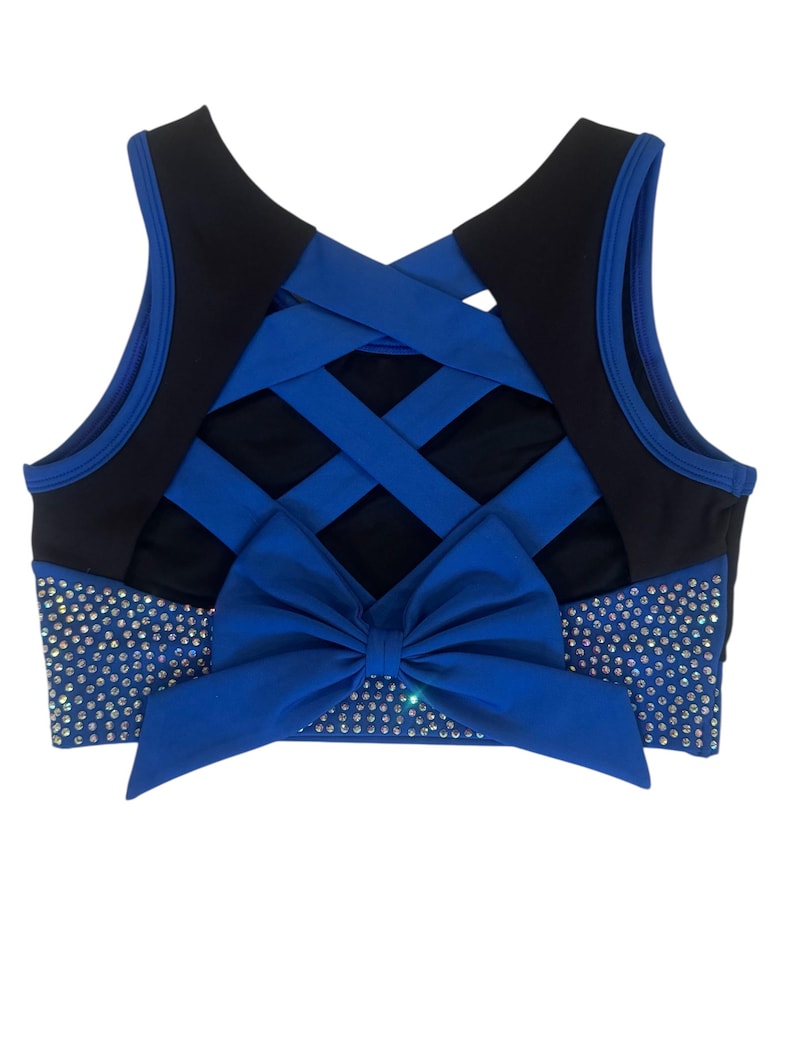 Peut inclure: Un soutien-gorge de sport bleu et noir avec un dos crois&eacute;. L'avant pr&eacute;sente un grand n&oelig;ud bleu et est orn&eacute; de strass &eacute;tincelants. Le soutien-gorge est con&ccedil;u pour les activit&eacute;s sportives.