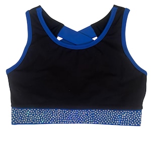 Peut inclure: Soutien-gorge de sport noir avec bordure bleue et dos crois&eacute;. Le soutien-gorge pr&eacute;sente une bande bleue en bas orn&eacute;e de strass &eacute;tincelants. Con&ccedil;u pour les activit&eacute;s sportives.