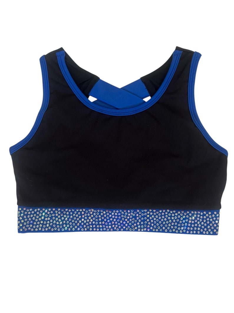 Peut inclure: Soutien-gorge de sport noir avec bordure bleue et dos crois&eacute;. Le soutien-gorge pr&eacute;sente une bande bleue en bas orn&eacute;e de strass &eacute;tincelants. Con&ccedil;u pour les activit&eacute;s sportives.