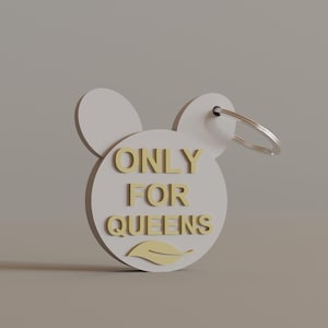 May include: A white keychain in the shape of a mouse head with the words "ONLY FOR QUEENS" in gold lettering. The keychain has a silver ring for attaching keys.