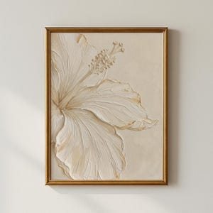 Può includere: Un'opera d'arte incorniciata raffigurante un fiore di ibisco color crema con un effetto tridimensionale strutturato. I petali e gli stami del fiore sono finemente dettagliati. L'opera d'arte è incorniciata in una cornice color oro, creando un'estetica classica ed elegante.