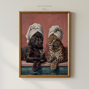 Puede incluir: Obra de arte enmarcada que presenta una pantera negra y un leopardo con turbantes de toalla blancos, sosteniendo copas de martini. La pintura tiene un marco dorado y el texto "Muse of Meow" en la parte superior.