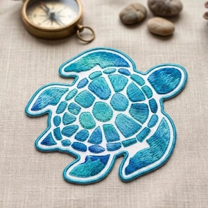 May include: Embroidered sea turtle patch in shades of blue and teal, with a white background and a blue border. The patch is a detailed, textured design, perfect for adding to clothing or accessories. The patch is approximately 4 inches wide.