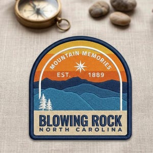 Op de afbeelding: Geborduurde patch met een berglandschapontwerp. De patch bevat de tekst "Mountain Memories" en "Blowing Rock North Carolina". Het ontwerp omvat een zonsonderganghemel, bergen en bomen.
