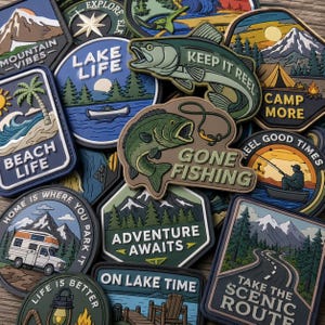 May include: A collection of colorful rubberized patches featuring outdoor themes, including mountains, lakes, fishing scenes, and camping motifs with text such as Lake Life, Keep It Reel, Gone Fishing, and Adventure Awaits.