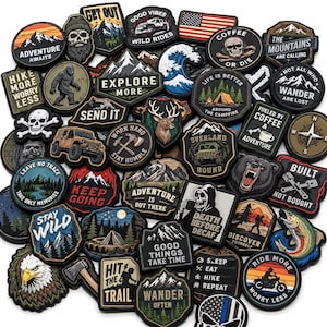 May include: A collection of assorted embroidered patches featuring outdoor themes, including mountains, skulls, wildlife, vehicles, and text such as Adventure Awaits, Explore More, Stay Wild, and Coffee or Die, arranged in a dense, overlapping pile.