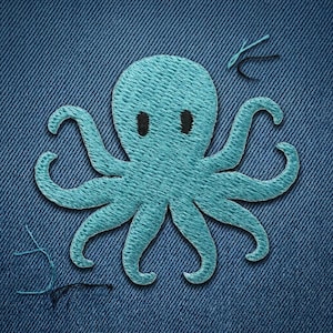 May include: A light blue embroidered octopus patch with black eyes, stitched onto a blue denim fabric. The octopus has eight curved tentacles. Loose threads are visible near the patch, adding a handcrafted feel. The design is simple and cartoon-like.