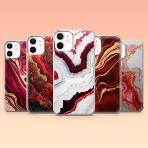 May include: Five phone cases with abstract designs in red, gold, and white, reminiscent of marble or agate. Each case has a clear border and a camera cutout. The cases are arranged in a row, showcasing different patterns and colour combinations.