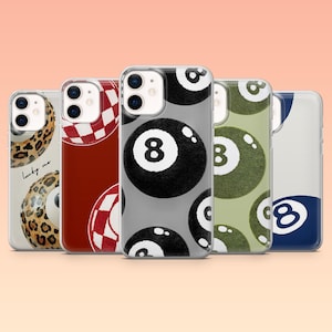 May include: A collection of phone cases with various designs. The cases feature a leopard print, a red and white checkered pattern, and several pool ball designs, including the number 8 and number 3. The cases are clear with a glossy finish.