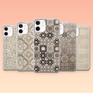 Op de afbeelding: Vijf telefoonhoesjes met verschillende tegelpatronen in neutrale tinten. De ontwerpen omvatten geometrische vormen, bloemmotieven en een mix van lichte en donkere tinten. De hoesjes zijn gemaakt van transparant plastic en hebben een glanzende afwerking.