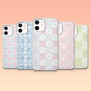 May include: Five phone cases with pastel patchwork designs. The cases feature patterns of bows, floral prints, and plaid in shades of pink, blue, and green. The cases are arranged in a row, showcasing the variety of designs.