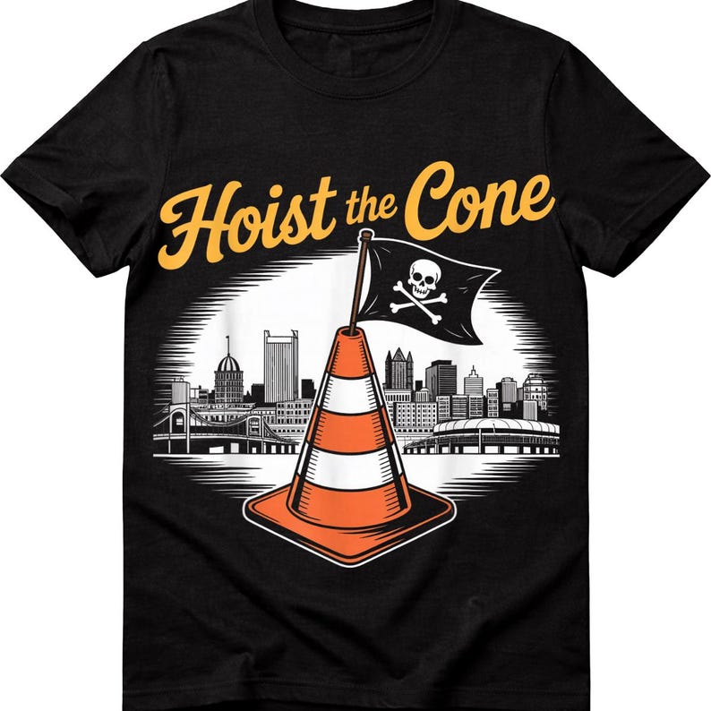 May include: Black t-shirt with a graphic featuring an orange and white traffic cone with a skull and crossbones flag, the text "Hoist the Cone", and a city skyline.