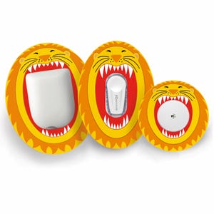 May include: Three medical device covers with a lion design. The covers are yellow and orange with a red interior, featuring a lion's face with an open mouth. The devices are white and fit inside the lion-shaped covers.