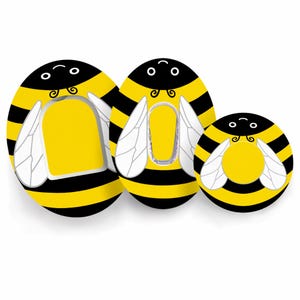 Może przedstawiać: Trzy obiekty w kształcie pszczół z żółto-czarnymi paskami. Każdy ma żółty środek, białe skrzydła i czarną głowę z uśmiechniętą twarzą. Obiekty różnią się rozmiarem, największy po lewej.