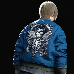 Puede incluir: Chaqueta bomber azul con un gran parche trasero con una calavera, un esqueleto y el texto "USA 1995". La chaqueta tiene cuello, puños y dobladillo de canalé. La chaqueta es de color azul vibrante.