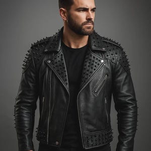 May include: Black leather jacket with studded accents on the shoulders, collar, and lower hem. The jacket features a classic asymmetrical zipper closure, quilted shoulder detailing, and a sleek, modern design.