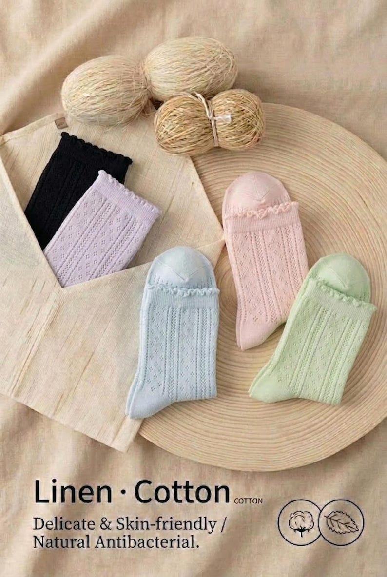 May include: Assortment of colorful socks in black, lavender, light blue, pink, and green, with a delicate openwork design. The socks are displayed with yarn balls and text that reads "Linen &bull; Cotton".