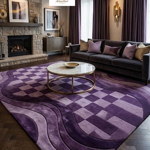 Könnte beinhalten: Ein großer rechteckiger Teppich mit einer Farbpalette in Dunkelviolett und Lavendel, der in der Mitte ein geometrisches Schachbrettmuster aufweist, umgeben von fließenden, geschwungenen Linien, die zu den Rändern des Bodenbelags verlaufen.