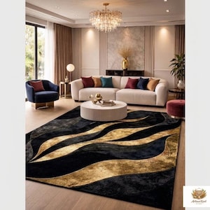 May include: A rectangular area rug featuring a flowing, abstract wave pattern in deep black and metallic gold tones. The rug has a textured surface with high-contrast curves that sweep across the floor, creating a bold visual focal point.