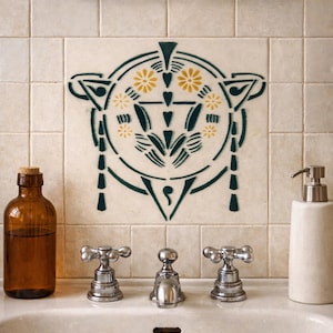 Può includere: Un lavandino del bagno con rubinetti cromati, una bottiglia di vetro marrone e un dosatore di sapone bianco. La parete presenta una piastrella decorativa con un motivo floreale verde e giallo. Uno specchio è sopra la piastrella.