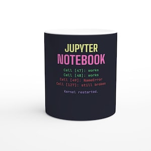 May include: A dark navy ceramic mug featuring the text JUPYTER NOTEBOOK in yellow and pink, followed by lines of code text in green, red, and orange reading Cell [47]: works, Cell [48]: works, Cell [49]: NameError, Cell [127]: still broken, and Kernel restarted.
