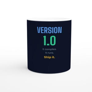 以下が含まれることがあります： 濃いネイビーブルーのセラミック製マグカップ。水色の「VERSION」、大きな緑色の「1.0」、白色の「It compiles. It runs.」という文字がプリントされています。その下には黄色の「Ship it.」という文字があります。マグカップの内側は白く、円筒形をしています。