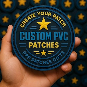 Puede incluir: Un parche redondo de PVC azul marino con texto amarillo que dice "CREATE YOUR PATCH" y "CUSTOM PVC PATCHES". Una estrella amarilla está en el centro. El parche se sostiene en una mano, con un fondo de parches similares.