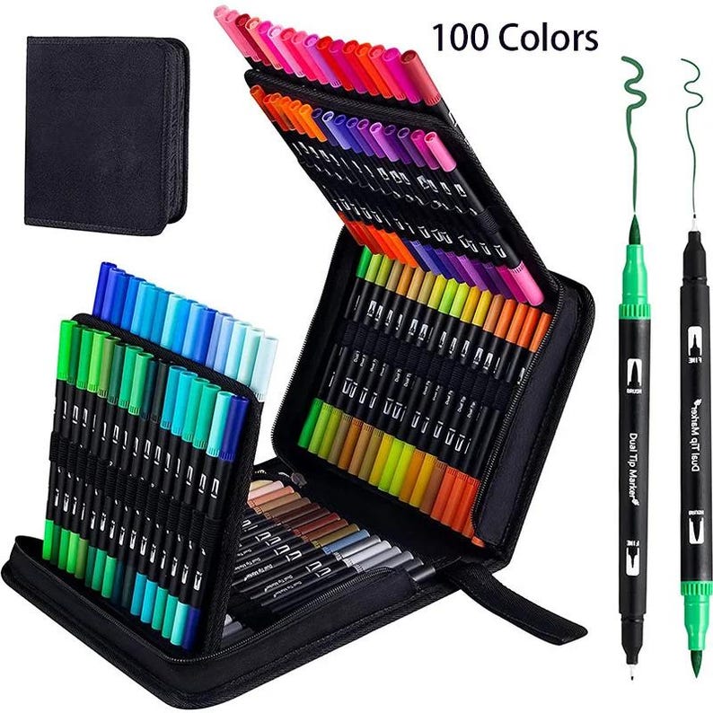 Op de afbeelding: Een set van 100 markers met dubbele punt in een zwarte etui met ritssluiting. De markers zijn in rijen op kleur gerangschikt, waaronder roze, oranje, paars, groen, blauw en neutrale tinten. Twee losse markers tonen de penseelpunten.