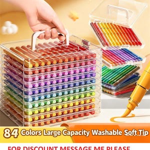 K&ouml;nnte beinhalten: Ein durchsichtiger Kunststoffkoffer mit 84 farbigen Soft-Tip-Markern, die in Regenbogenfarben angeordnet sind. Der Koffer hat einen wei&szlig;en Griff und ist mit mehreren Markierschichten gestapelt. Der Text auf dem Bild lautet "84 Colors Large Capacity Washable Soft Tip".