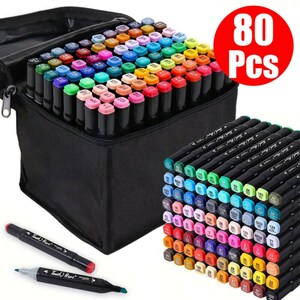 Könnte beinhalten: Eine schwarze Reißverschlusstasche mit 80 farbigen Markern. Die Marker haben schwarze Schäfte und farbige Kappen. Zwei Marker befinden sich außerhalb der Tasche, einer mit roter Kappe und einer mit grüner Kappe. Ein roter Kreis mit dem Text "80 Pcs" befindet sich oben rechts.