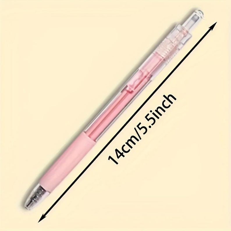 May include: A retractable ballpoint pen with a clear plastic barrel and a light pink inner ink tube. The pen features a solid light pink grip section near the tip and a clear click mechanism at the top. The total length is 5.5 inches.