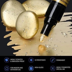 Könnte beinhalten: Ein goldfarbener Metallic-Marker mit schwarzer Kappe wird neben drei goldfarbenen Steinen gezeigt. Der Marker gibt goldfarbene Tinte auf eine Oberfläche ab. Das Bild enthält auch Text, der lautet: Hoch kratz- und abriebfest, UV-Beständigkeit, Permanent, Für den Innen- und Außenbereich, Hochglanz und Hochpigmentierte Spezialtinte.