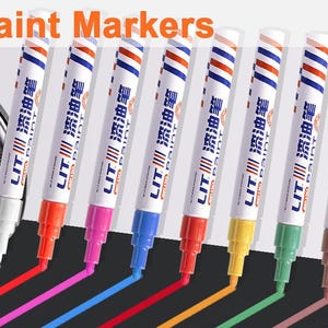 Puede incluir: Un juego de 12 marcadores de pintura con cuerpos blancos, tapas a rayas rojas y azules y caracteres chinos. Cada marcador tiene una punta de color que coincide con el color de la tinta, incluyendo blanco, rojo, rosa, azul, naranja, amarillo, verde, marrón y morado.