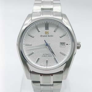 Peut inclure: Une montre-bracelet automatique Grand Seiko argentée avec un cadran argenté texturé. La montre présente un affichage de la date à 3 heures et un bracelet en acier inoxydable. Le cadran porte l'inscription "Grand Seiko" et "Automatic Hi-Beat 36000".