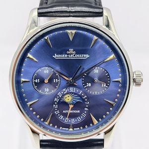 May include: A luxury wristwatch with a blue face and a black leather band. The watch features multiple sub-dials, gold-colored accents, and the Jaeger-LeCoultre logo. The watch has a silver-colored case and a crown on the right side.