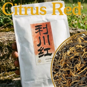 Könnte beinhalten: Ein weißer Beutel Citrus Red Tee mit einem Etikett mit schwarzen chinesischen Schriftzeichen auf rotem Grund und dem Text Lichuan Black Tea Net Wt 4 oz. Ein kreisförmiger Einsatz zeigt getrocknete, gedrehte dunkelbraune und goldene Teeblätter.