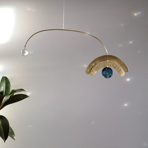 Kinetic sculpture art light catcher handmade in brass for modern interior with crystal to catch the light