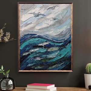 May include: An oil painting of the ocean with a school of fish and seagulls. The artwork features textured brushstrokes in shades of blue, teal, and white, framed in a gold-toned wooden frame. The painting evokes a sense of the sea and sky.