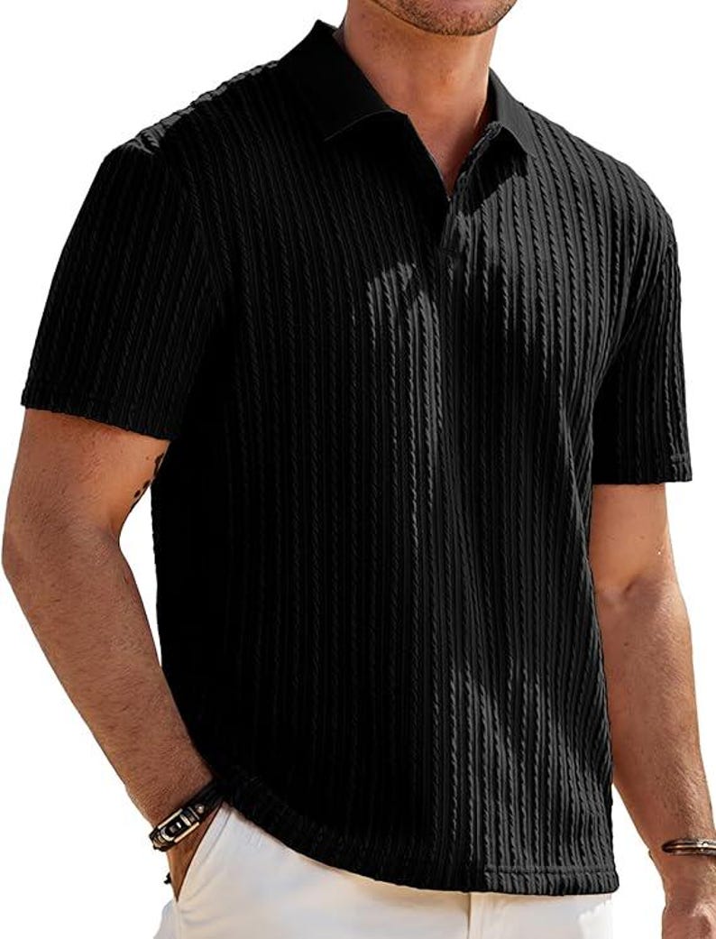 May include: A black short-sleeved polo shirt featuring a vertical ribbed texture throughout the fabric. The garment has a classic collar and a buttonless placket design, providing a clean and uniform appearance across the front and sleeves.