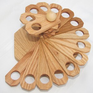 May include: A wooden spiral-shaped stand with multiple circular holes, perfect for organizing and displaying items like pens, pencils, or paintbrushes. The stand is made of light brown wood and has a natural finish.