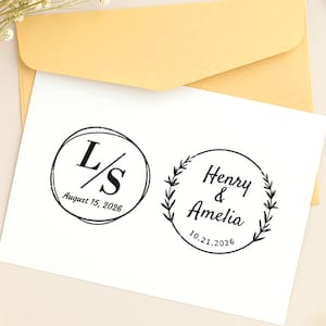 Puede incluir: Dos sellos de tinta negra sobre papel blanco. Un sello presenta las letras "L/S" dentro de un círculo con la fecha "August 15, 2026". El otro sello dice "Henry & Amelia" con la fecha "10.21.2026" dentro de una corona.