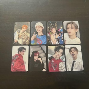 May include: A collection of eight rectangular photo cards featuring images of young people. The cards display various poses and outfits, with diverse hairstyles and expressions. The background is a dark, solid color.