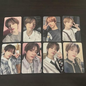 May include: Eight rectangular photo cards featuring images of a person. The cards are arranged in two rows of four. The person has brown hair and is wearing various outfits. Some cards show the person making a peace sign.