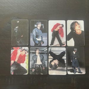 May include: A collection of eight rectangular photo cards featuring a person in various poses. The cards showcase the person in different outfits, including a leather jacket, red jacket, and black attire. The images are set against a dark background.